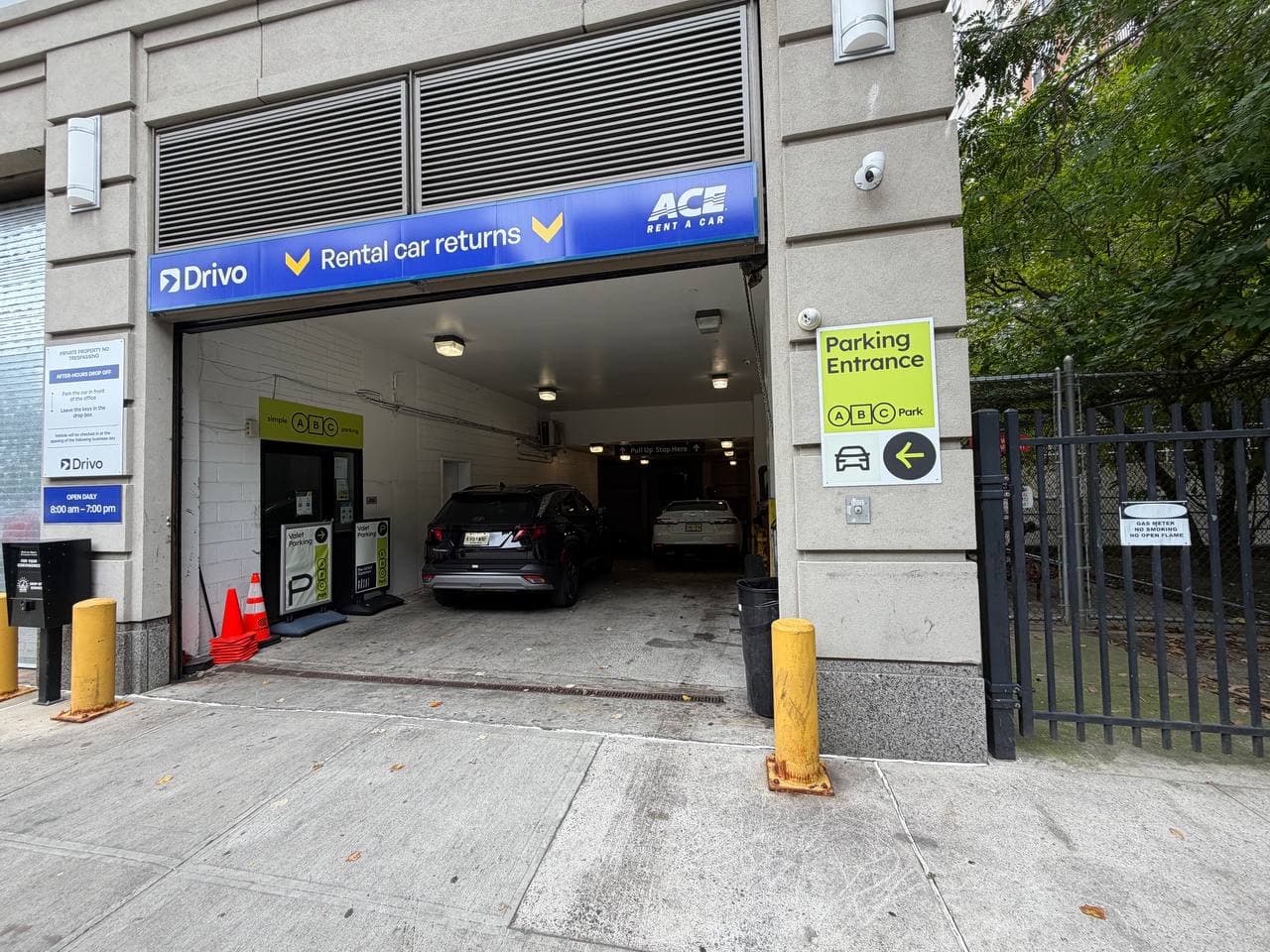 ABC Park garage entrance beneath the blue Drivo and ACE sign, with a lime Parking Entrance sign on the right-hand pillar.