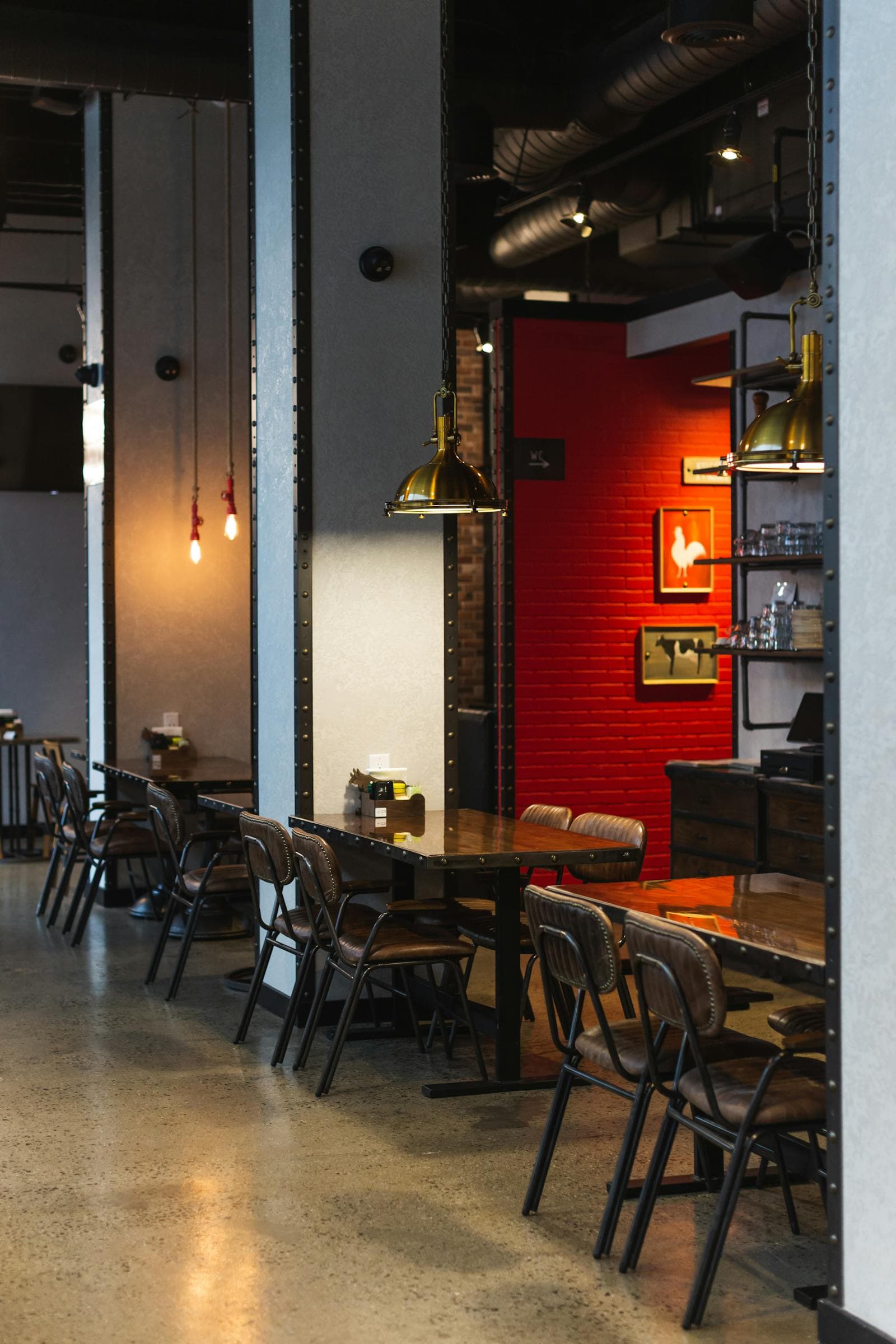 Warm pendant lights, leather chairs and wooden dining tables inside GOSHT in Brighton Beach.